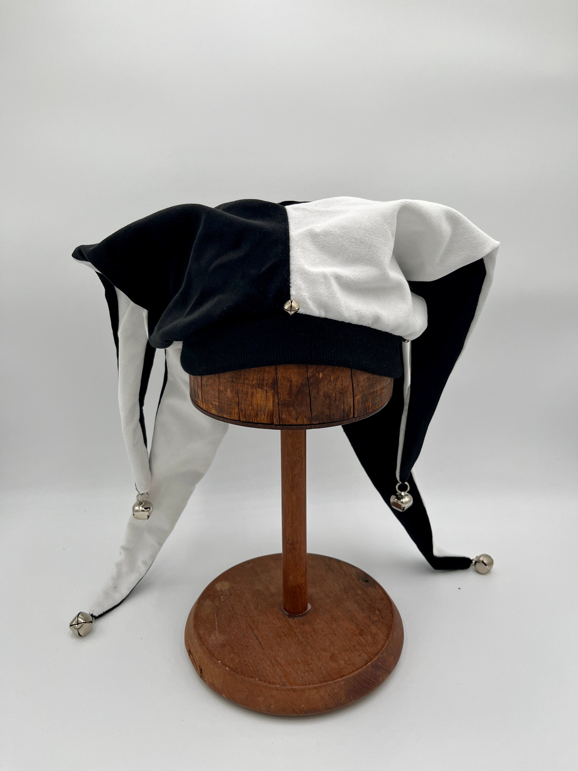 Handmade black white jester hat draped view, close-up of bells